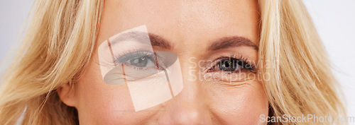 Image of Skincare, eyes and zoom, mature woman in anti ageing treatment portrait isolated on grey background in studio. Health, skin and beauty, happy model face, eye closeup in luxury spa collagen facial.