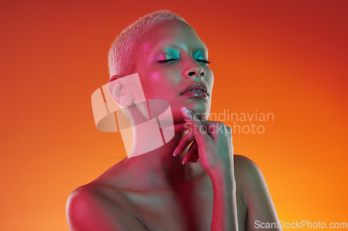 Image of Skincare, beauty and eyes closed, woman with neon makeup and light for creative advertising on orange background. Cyberpunk, art and model isolated for skin care and futuristic mockup space in studio