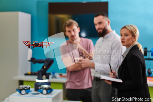 Image of A group of students working together in a laboratory, dedicated to exploring the aerodynamic capabilities of a drone