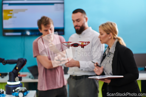 Image of A group of students working together in a laboratory, dedicated to exploring the aerodynamic capabilities of a drone