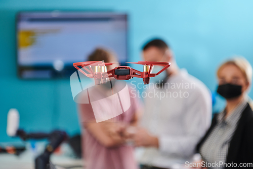 Image of A group of students working together in a laboratory, dedicated to exploring the aerodynamic capabilities of a drone