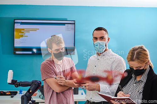 Image of A group of students working together in a laboratory, dedicated to exploring the aerodynamic capabilities of a drone