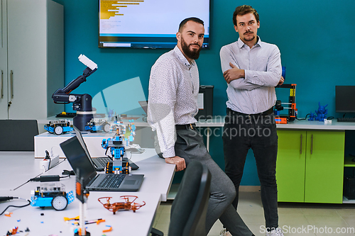 Image of A group of colleagues collaborate in a lab while testing a 3D printer, demonstrating their commitment to technological advancement and scientific research.