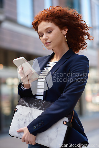 Image of Business woman, phone and walking in the city for communication, social media or texting and chatting. Female ginger typing on smartphone taking walk with 5G connection, mobile app or travel in town