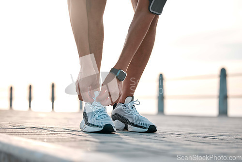 Image of Fitness, running and man tie shoes by ocean ready for exercise, marathon training and cardio workout. Start sports mockup, athlete and feet of male runner with shoelace for wellness and health