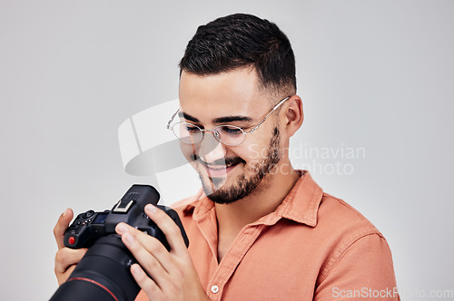 Image of Photographer, camera and art with a creative man in studio on a gray background for modern photography. Media, production and photoshoot with a male photo professional or artist working backstage