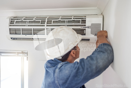 Image of Air conditioner, ac repair and building hvac maintenance of a handyman and builder on home renovation. Electric technician, service worker and contractor in a house for equipment installation on wall