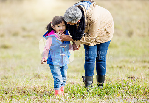 Image of Grandmother, happy girl and nature walk of a kid with senior woman in the countryside. Outdoor field, grass and elderly female with child on a family adventure on vacation with happiness and fun