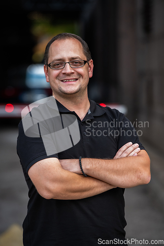 Image of A successful businessman with crossed arms, posing outdoors