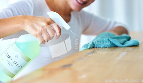 Image of Closeup, hands and woman with spray bottle, detergent and hygiene for protection, wellness and spring cleaning. Zoom, female cleaner and lady with liquid, table and surface disinfection and safety