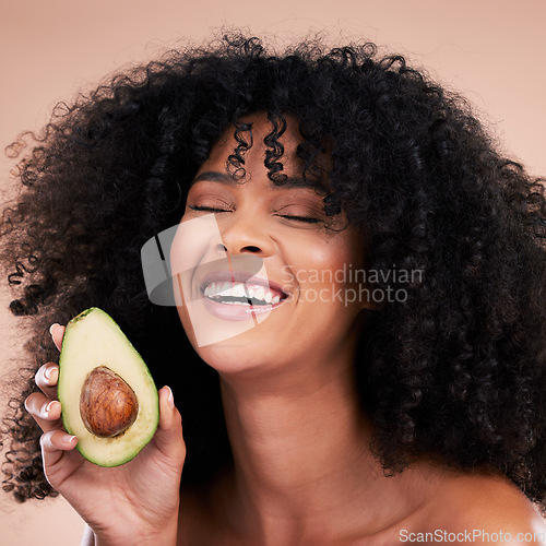 Image of Black woman, studio and avocado for beauty, smile and skincare with health, wellness and self care by background. Happy gen z model, african and fruit for natural aesthetic, healthy nutrition or diet