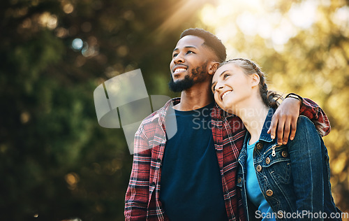 Image of Love, interracial and couple in nature, freedom and happiness with romance, carefree and bonding together. Romantic, black man and woman hug, loving and outdoor for fun, relationship and cheerful