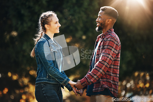 Image of Love, date and interracial couple holding hands in nature for a walk, romamce and gratitude. Support, trust and black man with a woman, affection and walking in marriage in a park in Germany