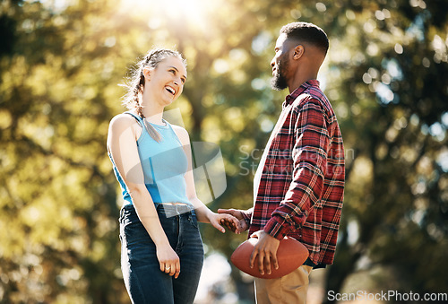 Image of Couple, American football in park and happy together, summer with hand holding outdoor and sports in the sun. Commitment, trust and fitness, black man and woman, interracial relationship and care