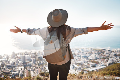 Image of Woman, tourist and hiking or travel in city for freedom, adventure or backpacking journey on mountain in nature. Female hiker with open arms enjoying fresh air break, trekking or scenery of Cape Town