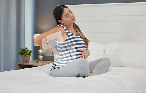 Image of Pregnant, bed and woman with back pain, maternity issues and anxiety with ache, muscle strain and cramps. Pregnancy, female or lady in bedroom, contractions and anxious with health problems or stress