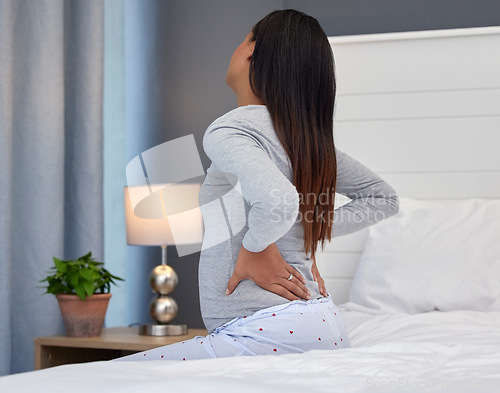 Image of Tired, burnout and pregnant woman with back pain on a bed for rest, injury and fatigue. Healthcare, stress and girl with backache during pregnancy in her bedroom with morning sickness and cramps