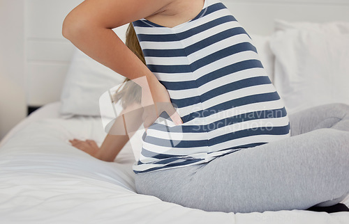 Image of Tired, cramps and pregnant woman with back pain on a bed for rest, break and maternity leave. Sick, injury and girl with backache, fatigue and stress during pregnancy in a bedroom for motherhood