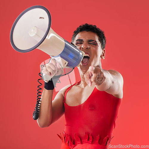 Image of Anger, gay and portrait of a man with a megaphone isolated on a red background in a studio. Decision, freedom and person shouting and talking into a speaker while pointing with choice on a backdrop