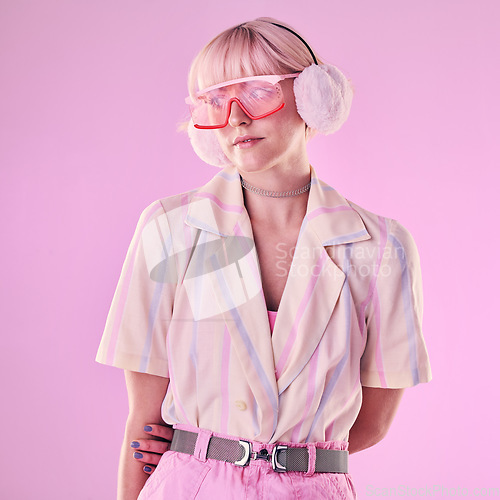 Image of Fashion, glasses and woman on pink background for beauty, vaporwave style and cosmetics in studio. Creative aesthetic, makeup and female model with earmuffs, trendy clothes and cyberpunk accessories