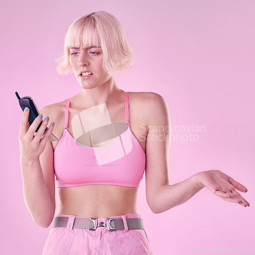 Image of Retro phone, fashion and woman with glitch on pink background with network issue, problem or spam. Creative aesthetic, beauty and confused girl with vintage cellphone, makeup and cosmetics in studio