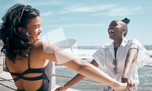 Image of Holding hands, friends and women dance at beach, having fun and laughing together outdoors. Comic, freedom and girls laugh at funny comedy or joke, dancing and enjoying time at promenade seashore.