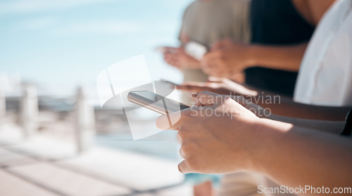 Image of People, hands and phone in networking at beach chatting, texting or social media together in the outdoors. Hand of group on smartphone for communication, typing or data sharing mobile app on mockup