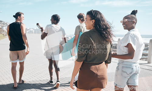 Image of Diversity, walk and friends on beach promenade while on summer vacation or weekend trip together. Friendship, multiracial and group of people people walking, bonding and talking by ocean on holiday.