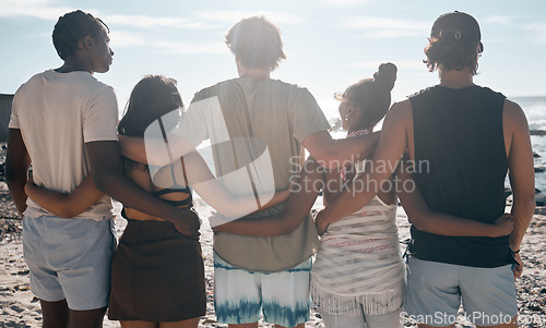 Image of Friends, back or standing hug by beach, ocean or sea in social gathering, group vacation or relax summer holiday. Men, women or diversity people in embrace, travel bonding or nature community support