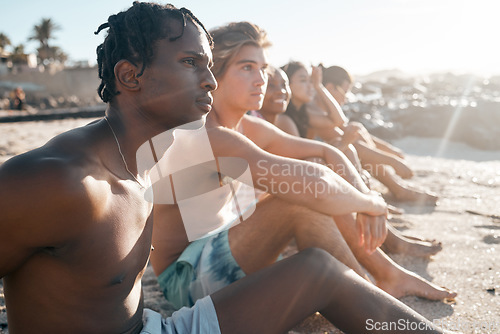 Image of Black man, bonding and sitting on beach sand with friends in summer holiday, vacation break or community travel. Relax, diversity and people in swimsuit by sea for nature freedom or social gathering