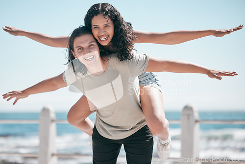 Image of Freedom, travel and portrait of piggyback couple at beach, happy and playful against blue sky background. Face, airplane and fun woman with man on vacation, holiday or summer trip in Mexico together