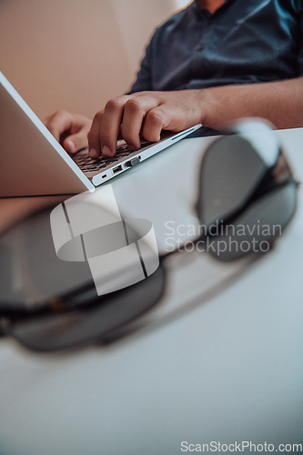 Image of Close-up photo of a programmer typing on a laptop