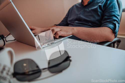 Image of Close-up photo of a programmer typing on a laptop
