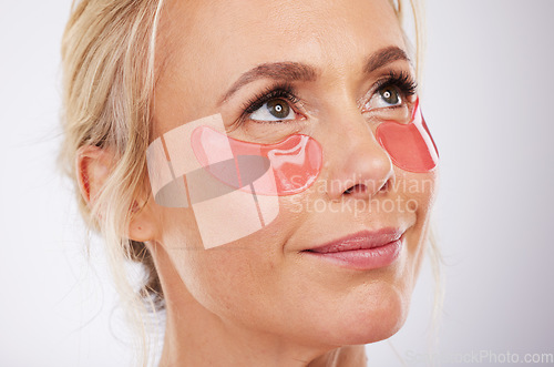 Image of Skincare, collagen eye mask and mature woman with anti ageing treatment isolated on grey background in studio. Health, skin and beauty, model face with smile and patch on eyes for luxury spa facial.
