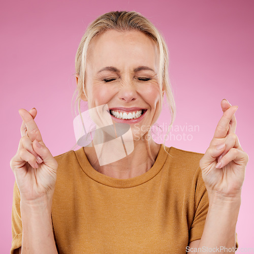 Image of Woman, fingers crossed and hope in studio, pink background and smile face. Female model wish for luck with hands of bonus, promotion and winning giveaway for emoji sign, competition prize and lottery