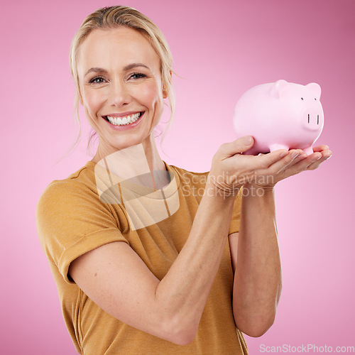 Image of Woman, piggy bank and portrait for savings on pink background, studio and backdrop. Happy female holding financial tin for loan, profit or finance investment with cash, money and accounting budget