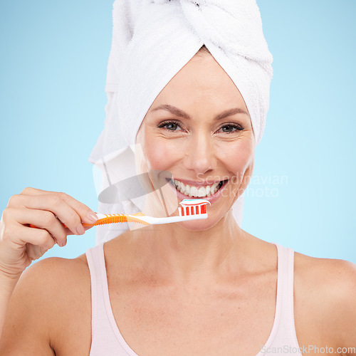 Image of Portrait, woman smile and toothbrush isolated on blue background for dental, mouth or orthodontics health. Beauty model or mature person for brushing teeth, cleaning product and toothpaste in studio