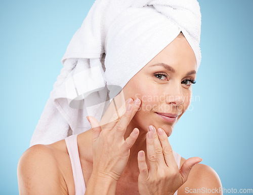 Image of Portrait, shower towel and woman touch face in studio for beauty, dermatology or blue background. Female model, skincare and facial aesthetic of healthy shine, glow transformation and clean wellness