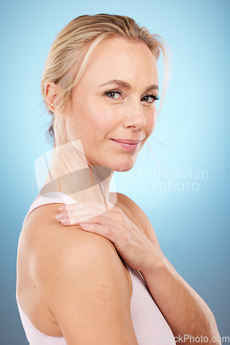 Image of Beauty, woman and portrait in studio for skincare, dermatology and wellness cosmetics on blue background. Happy mature female model, facial and smile for aesthetic glow, laser transformation and face