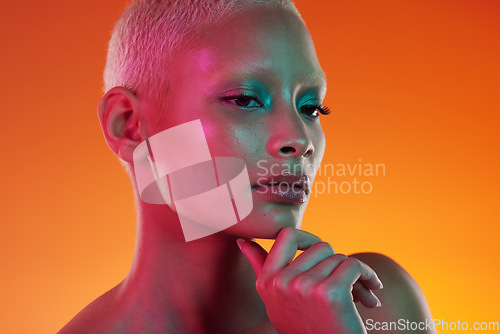 Image of Neon, beauty and portrait of woman thinking in face makeup and light in creative advertising on orange background. Cyberpunk, art and model isolated in skincare and futuristic mockup space in studio.