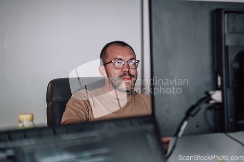 Image of A programmer diligently testing smartphone applications while sitting in their office.