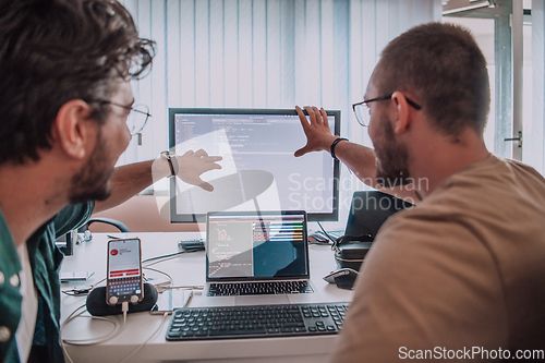 Image of Programmers engrossed in deep collaboration, diligently working together to solve complex problems and develop innovative mobile applications with seamless functionality.