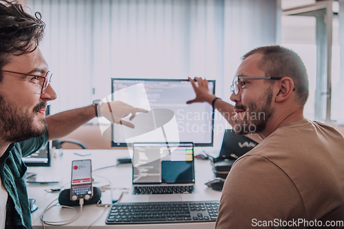 Image of Programmers engrossed in deep collaboration, diligently working together to solve complex problems and develop innovative mobile applications with seamless functionality.