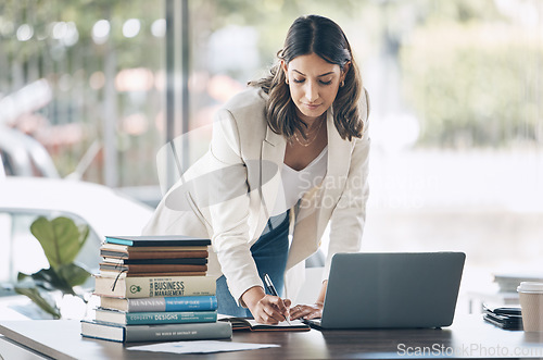 Image of Woman, serious or laptop for notebook writing, marketing strategy review or global planning schedule in office. Worker, employee or notes for technology startup, calendar management or growth goals