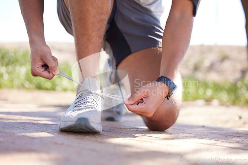 Image of Fitness, exercise and man tie shoes ready to start running, marathon training and endurance workout. Sports, nature trail and feet of male runner tying shoelace for wellness, health and performance