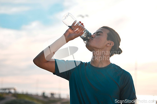 Image of Fitness, exercise and man drinking water for wellness, healthy lifestyle and hydration after workout. Sports mockup, sunset and male athlete with minerals for running, endurance training and cardio
