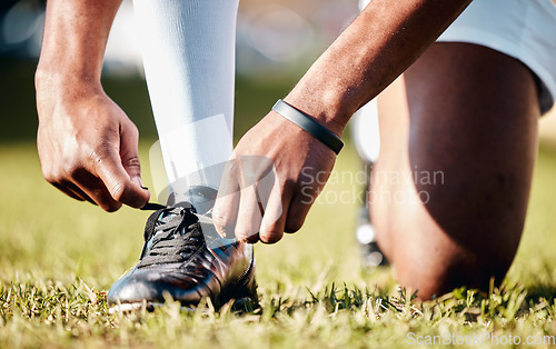 Image of Man, hands and shoe tying laces getting ready for sports training, exercise or match and game on grass field. Hand of male in preparation, tie shoes and sport for fitness, start or soccer practice