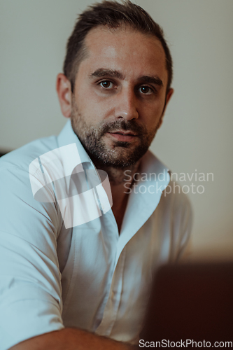 Image of A successful businessman is sitting in his office after a hard day's work