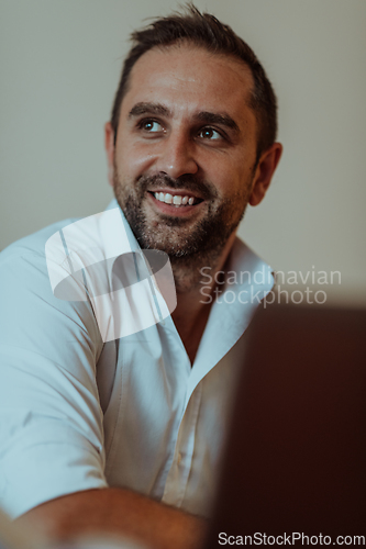 Image of A successful businessman is sitting in his office after a hard day's work