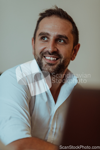 Image of A successful businessman is sitting in his office after a hard day's work